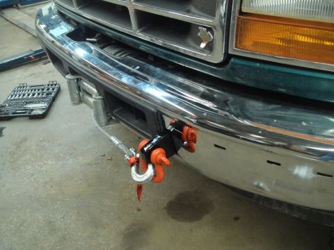 1996 Ford Bronco - A green Ford truck's front bumper shows a newly installed winch and hook, with a toolbox visible to the side.