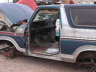 1979 Ford Bronco - Junkyard Bronco, likely a 1978 model, shows its interior with the driver's door ajar.
