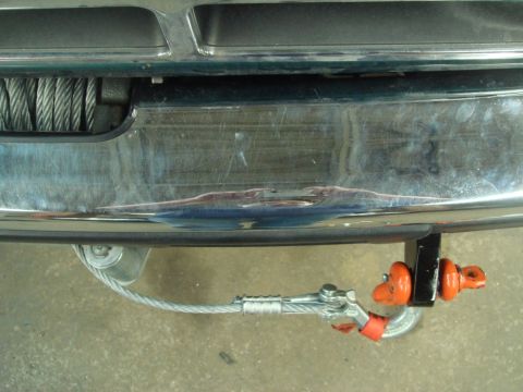 1996 Ford Bronco - Close-up of a vehicle's front bumper showing a winch and a tow hook with attached cable.