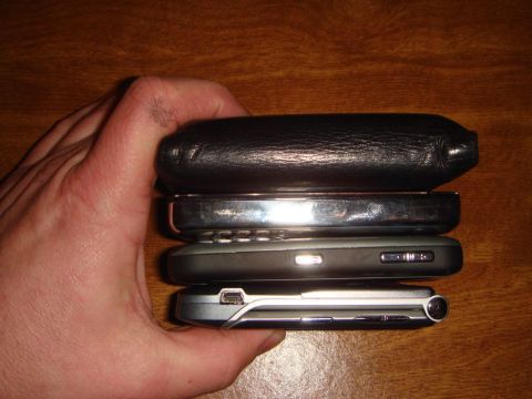 1996 Ford Bronco - A hand holds a stack of four cell phones, showing their side profiles.