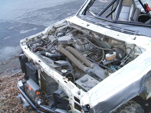 1995 Ford Bronco - The engine bay of a 1995 Ford Bronco shows a winch mounted on the front and a roll cage visible inside.