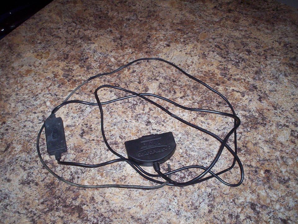 Two black electronic modules connected by wires. One module has text that appears to say 'SUPERCHARGER'