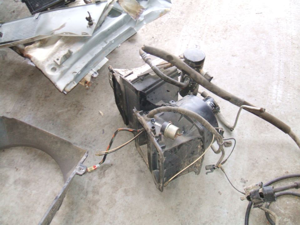 Disassembled vehicle AC evaporator and condenser unit with hoses and wiring