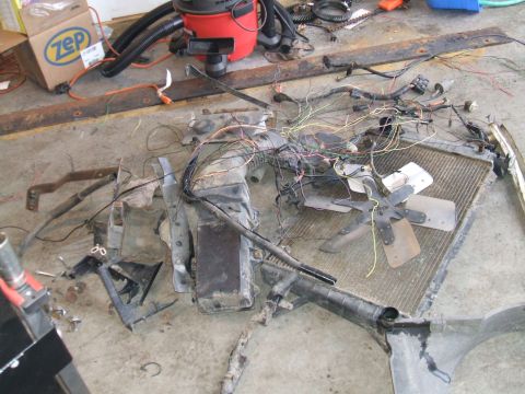 1995 Ford Bronco - Vehicle front end components, including the radiator and fan, are spread out on the floor.