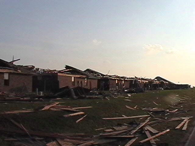 Buildings damaged by a tornado, with debris scattered on the ground