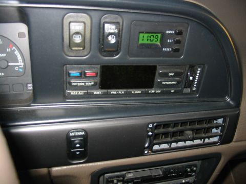 1993 Ford Taurus - Close-up of a 1990s Ford center dash stack showing rear-defrost and fog lamp switches, a green digital clock reading 11:09, and an electron…