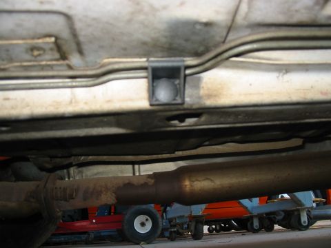 1993 Ford Taurus - Close-up view of a vehicle's undercarriage, revealing fuel lines and exhaust system components.