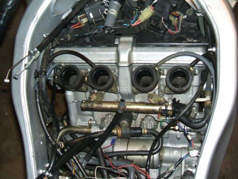 2004 Yamaha FZR600 - Close-up view of a motorcycle engine, showing the carburetor assembly and complex wiring harness.