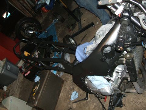 2004 Yamaha FZR600 - A motorcycle is partially disassembled in a garage setting, with various parts and tools visible.