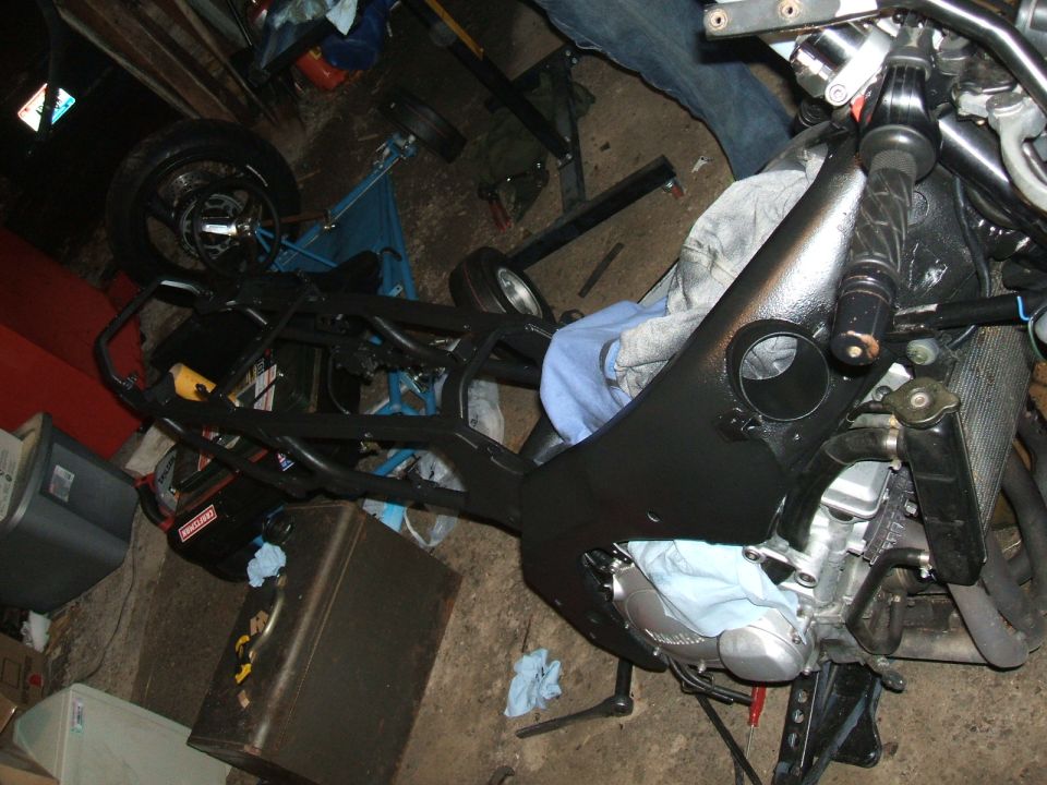 Bare vehicle frame and rear suspension during build in a garage