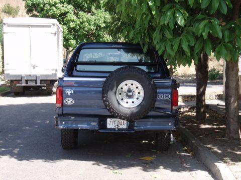 1995 Ford F-150 - Rear view of a 1995 Ford F-150 pickup truck parked next to a white box truck.