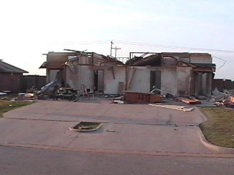 1979 Ford Bronco - A house shows extensive damage, with its roof and walls collapsed after a storm.