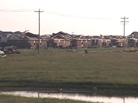 1979 Ford Bronco - Neighborhood shows extensive damage from a tornado, with debris scattered across the landscape.