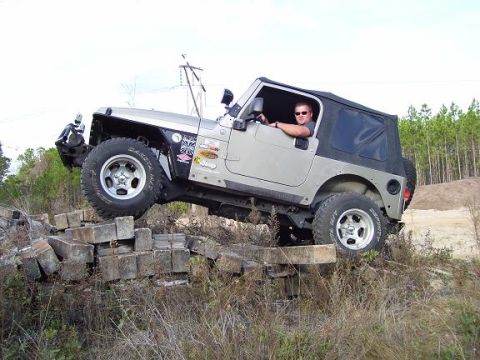 2004 Jeep TJ - A driver navigates a Jeep TJ over a rough obstacle course.