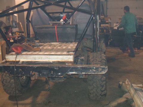 1995 Ford Bronco - Off-road vehicle with roll cage and large tires in a workshop setting.