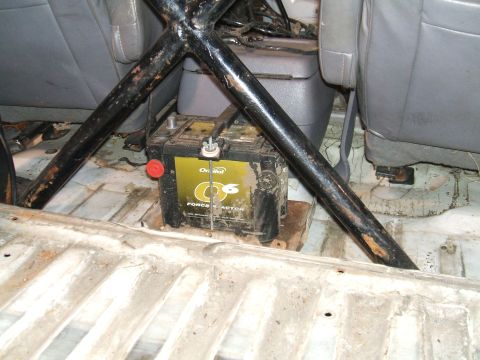 1995 Ford Bronco - Interior view of a vehicle's cabin, highlighting a battery and roll cage structure.