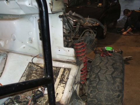 1995 Ford Bronco - Vehicle interior during a rebuild, with a large tire and suspension components visible.