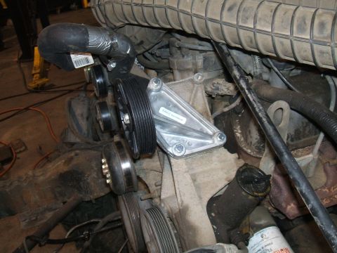 1995 Ford Bronco - Close-up of a vehicle's engine, focusing on the water pump and serpentine belt system.