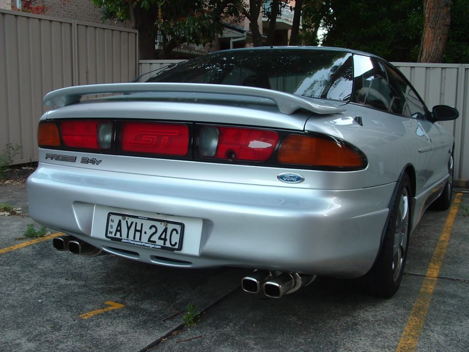 Rear view of a silver 1997 Ford Probe GT with a spoiler and dual exhaust pipes