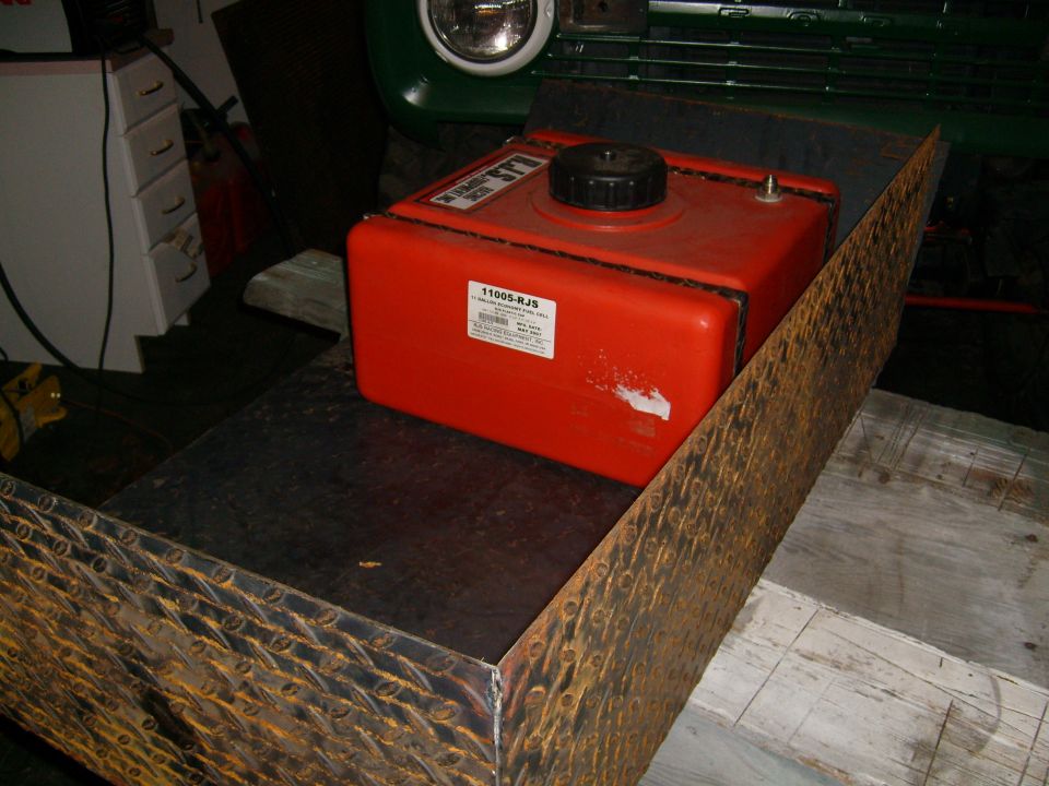 Red auxiliary fuel tank with visible text, inside a vehicle's interior