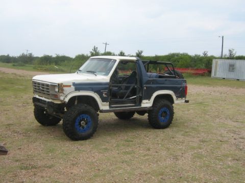 1986 Ford Bronco - This modified 1986 Ford Bronco features a lifted suspension, off-road tires, and an external roll cage.