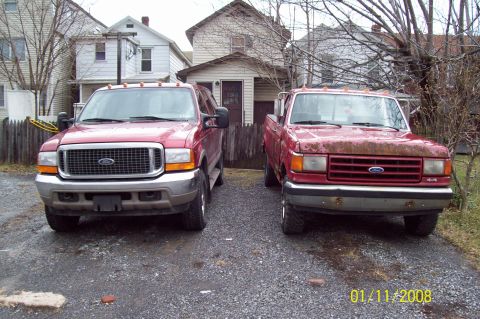 1989 Ford F-150 - Two Ford trucks, a 1992 F-250 and an Excursion, are parked in a gravel driveway.
