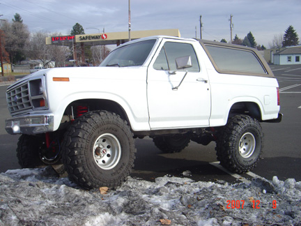 1983 Ford Bronco - This lifted Ford Bronco is parked in a lot with snow on the ground, with a Safeway store visible in the background.