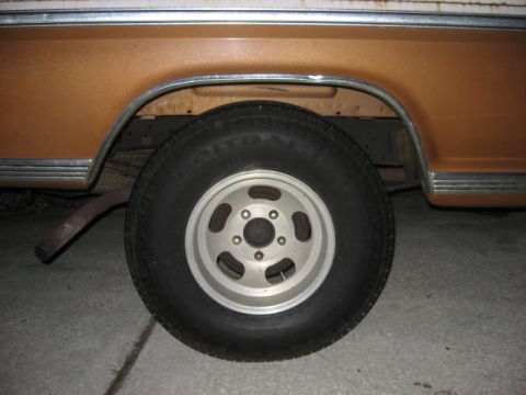 1972 Ford F-100 - Close-up of a truck's rear wheel and fender area, showing the tire and rim.