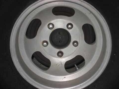 1972 Ford F-100 - A silver five-spoke wheel is shown in a close-up view, mounted on a black tire.