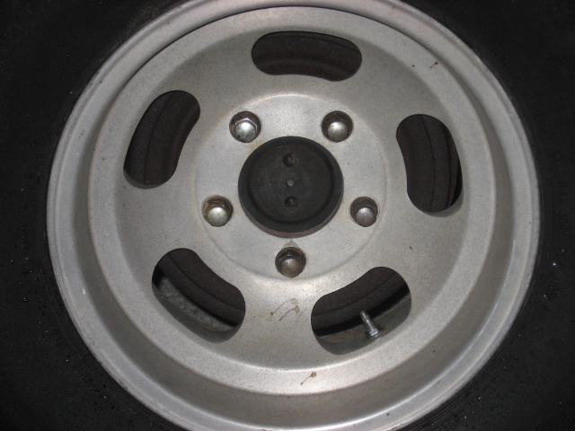 Close-up of a silver five-spoke wheel with a black tire