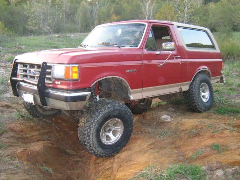 1988 Ford Bronco - This lifted 1987 Ford Bronco navigates rough terrain with its aggressive off-road tires and brush guard.