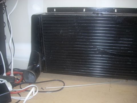 1991 Ford Mustang - A black intercooler is shown with various wires and hoses on the floor.
