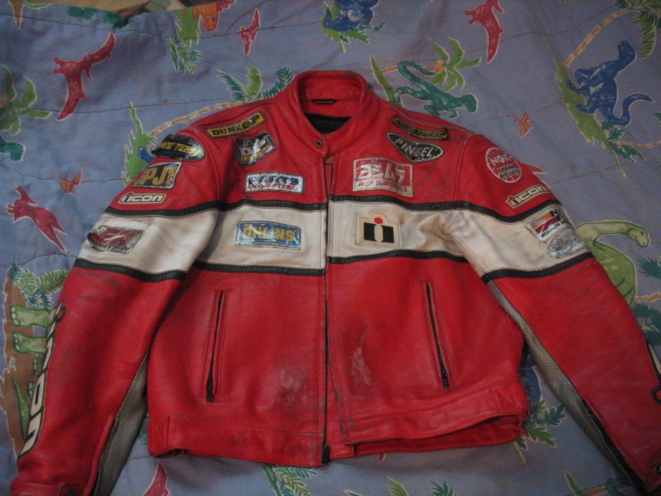 Red and white leather motorcycle jacket with multiple sponsor patches, including Yoshimura and Icon