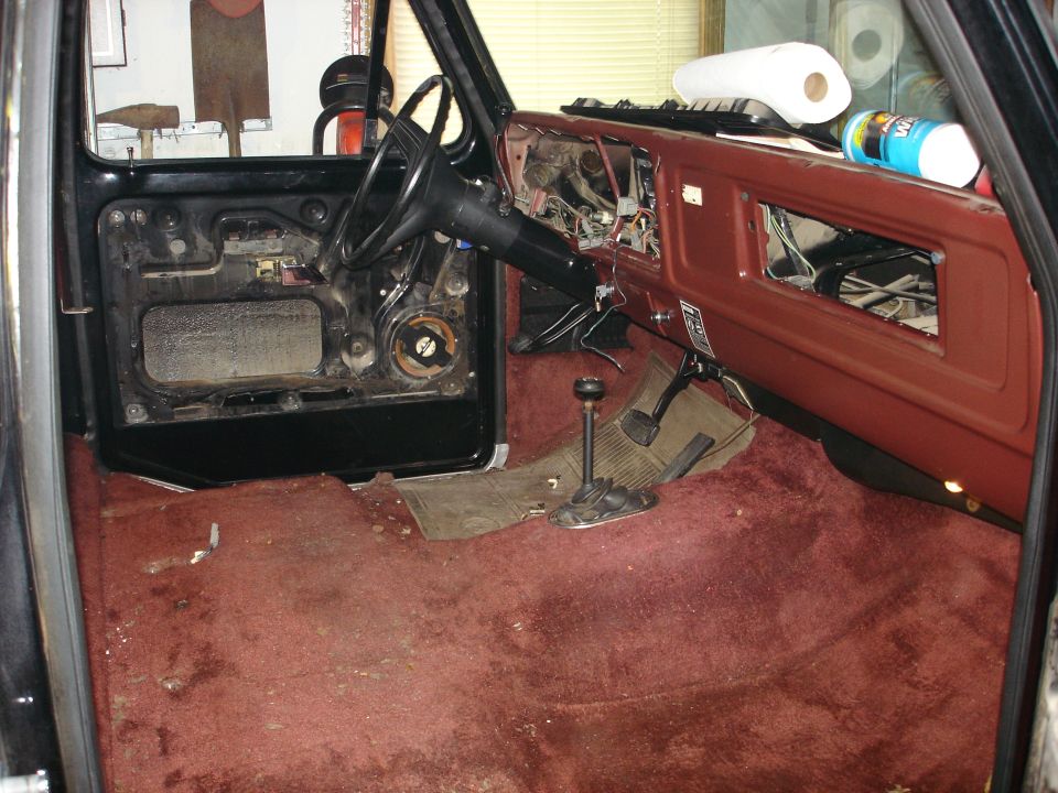1979 Ford F-150 interior with dashboard removed, door panel off, and red carpet