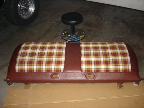 1979 Ford F-150 - A bench seat with a plaid insert and brown vinyl trim is shown, with a stool and tools in the background.
