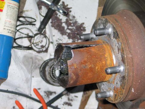 1994 Ford Bronco - Close-up of a severely damaged wheel hub assembly, showing broken splines and significant rust.