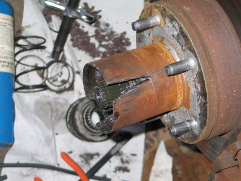 1994 Ford Bronco - Close-up of a damaged and rusted vehicle hub assembly, showing internal splines and surrounding parts.