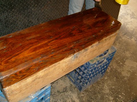 1974 Ford Bronco - A wooden chest rests on blue plastic crates, with a person's legs visible in the background.
