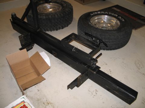 1995 Ford Bronco - Spare tire carrier and two tires on a concrete floor.