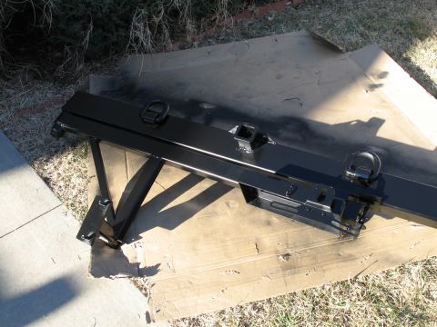 1995 Ford Bronco - A freshly painted trailer hitch receiver is drying on a piece of cardboard in the grass.