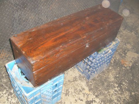 1974 Ford Bronco - A wooden chest rests on stacked blue plastic crates in a garage or workshop setting.