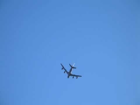 1995 Ford Bronco - An airplane is seen from below against a clear blue sky.