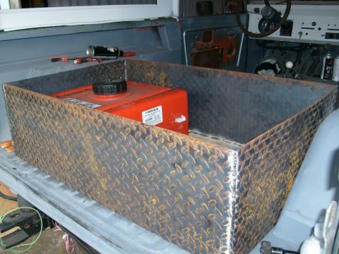 1974 Ford Bronco - A custom fuel tank is being installed in the rear of a vehicle, with tools nearby.