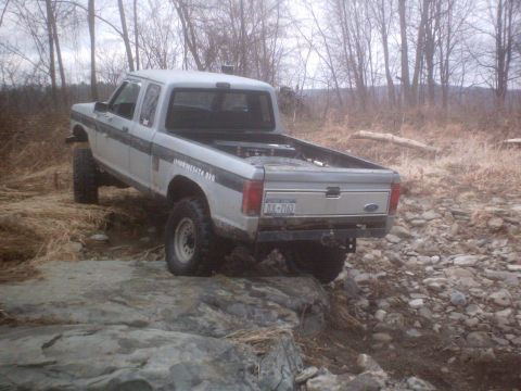 1990 Ford Ranger - A gray Ford Ranger pickup truck navigates a rocky terrain off-road.