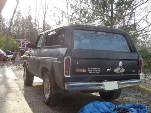 1979 Ford Bronco - A dark gray 1978 Ford Bronco is parked outdoors, showing its rear end with custom stickers.