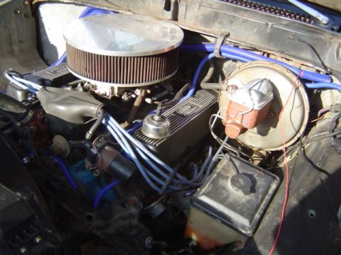 1979 Ford Bronco - Close-up view of an engine bay, an aftermarket air filter and blue hoses, with visible text from Supermotors.net.