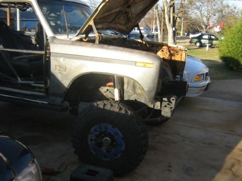 1986 Ford Bronco - A modified Ford F-series truck is parked outside with its hood up and large tires visible.