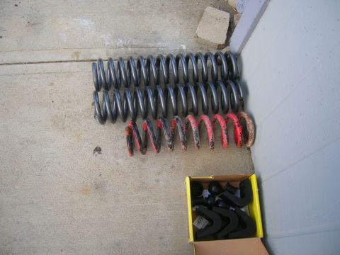 1979 Ford Bronco - Coil springs and suspension parts laid out on a concrete surface.