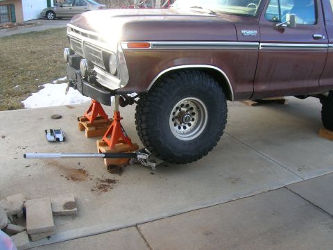 1979 Ford Bronco - The front suspension of a 1979 Ford Bronco is elevated on jack stands for maintenance.