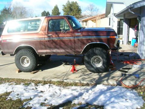 1979 Ford Bronco - A brown 1978 Ford Bronco with a white top is raised on jack stands, showing its lifted suspension.